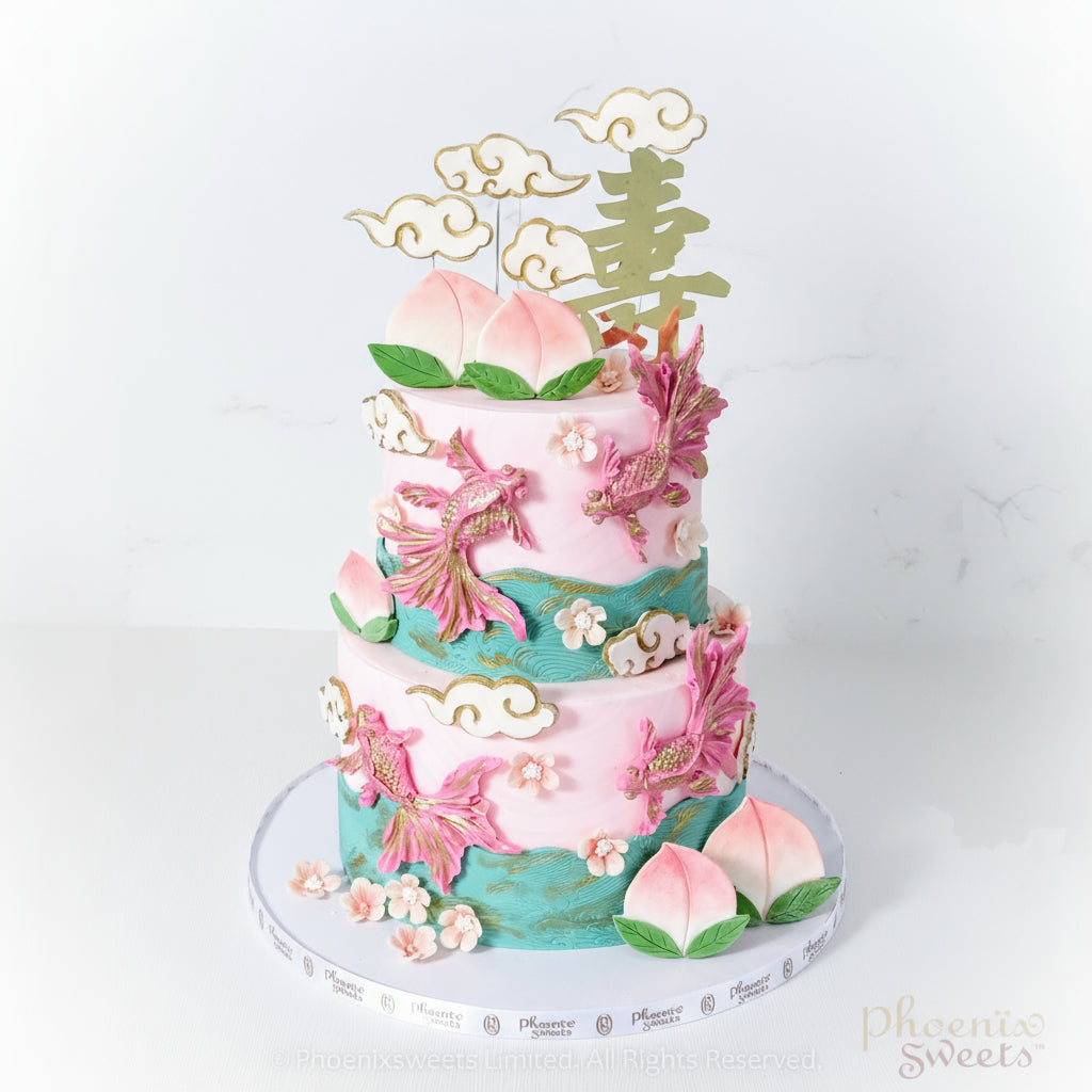 A multi-tiered fondant cake with gold fish and peach decorations, along with green and pink icing.